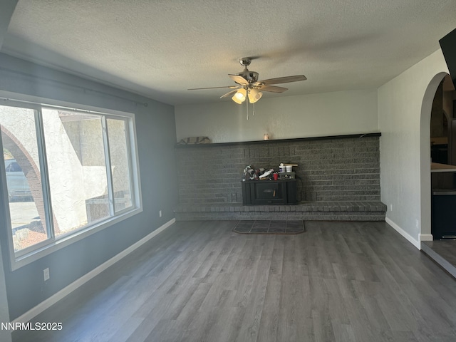 4440 Debra Ln, Winnemucca, NV 89445 - unfurnished living room with arched walkways, a textured ceiling, wood finished floors, and a ceiling fan