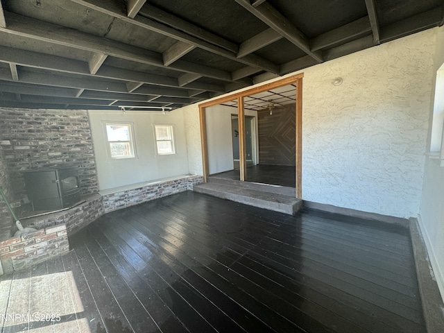 4440 Debra Ln, Winnemucca, NV 89445 - unfurnished living room with wood-type flooring, a wood stove, and a wood ceiling with exposed beams