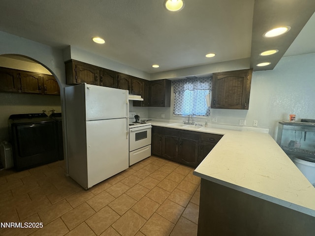 4440 Debra Ln, Winnemucca, NV 89445 - kitchen with white appliances, under cabinet range hood, light countertops, recessed lighting, and dark brown cabinetry