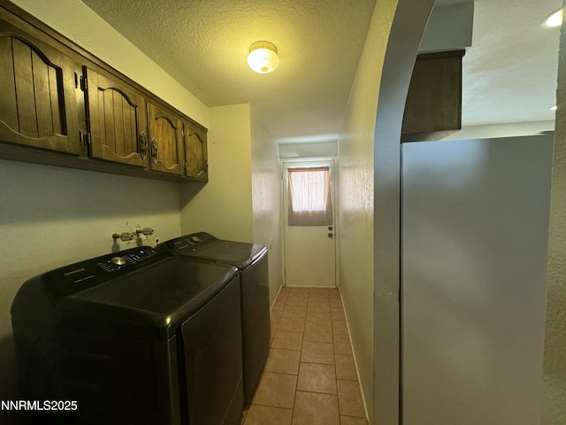 4440 Debra Ln, Winnemucca, NV 89445 - washroom featuring washer and clothes dryer, cabinet space, a textured ceiling, and light tile patterned floors
