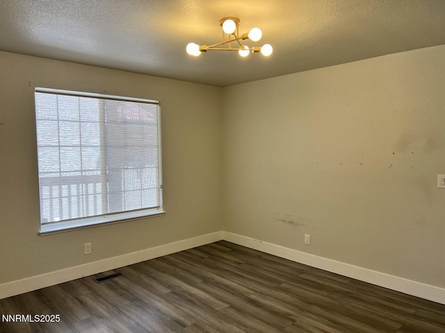 6845 Forsythia Way, Reno, NV 89506 - empty room with a chandelier, healthy amount of natural light, dark wood-style floors, and a textured ceiling