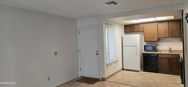 2111 Roundhouse Rd, Sparks, NV 89431 - kitchen featuring black appliances, light wood-type flooring, light countertops, plenty of natural light, and a textured ceiling