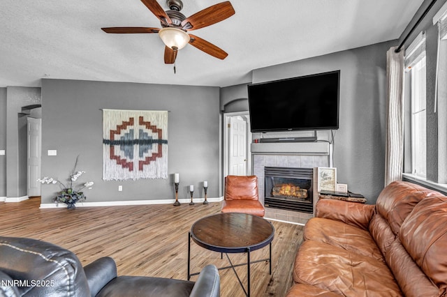 6230 Ingleston Dr Unit 212, Sparks, NV 89436 - living room featuring wood finished floors, ceiling fan, a tile fireplace, and a textured ceiling
