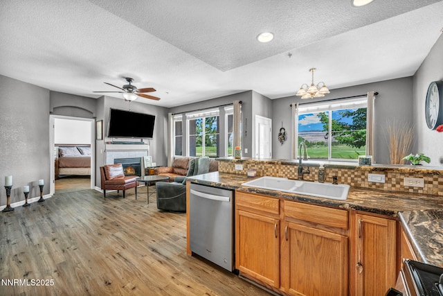 6230 Ingleston Dr Unit 212, Sparks, NV 89436 - kitchen with dishwasher, decorative backsplash, light wood-style floors, healthy amount of natural light, and a textured ceiling
