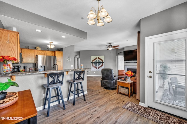 6230 Ingleston Dr Unit 212, Sparks, NV 89436 - kitchen with stainless steel fridge with ice dispenser, a peninsula, a chandelier, light wood-type flooring, and a breakfast bar
