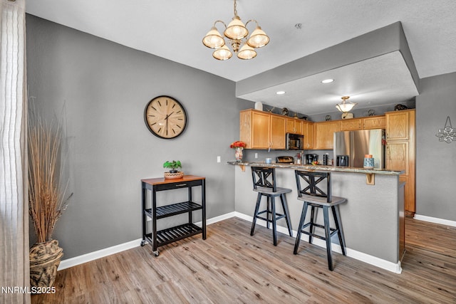 6230 Ingleston Dr Unit 212, Sparks, NV 89436 - kitchen with stainless steel refrigerator with ice dispenser, black microwave, light wood-style flooring, a chandelier, and recessed lighting