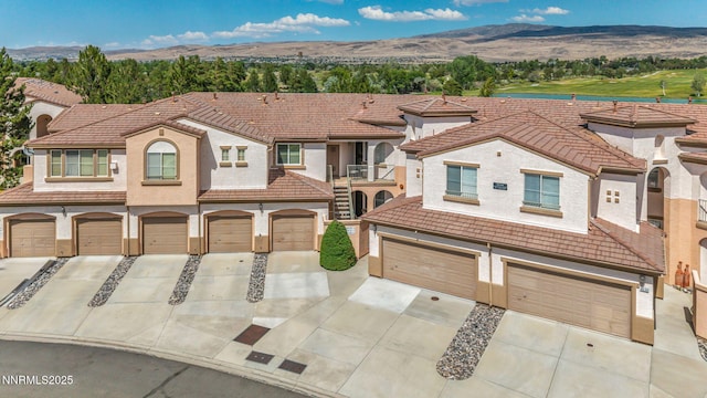 6230 Ingleston Dr Unit 212, Sparks, NV 89436 - view of front of property with driveway, a tiled roof, stucco siding, and a mountain view