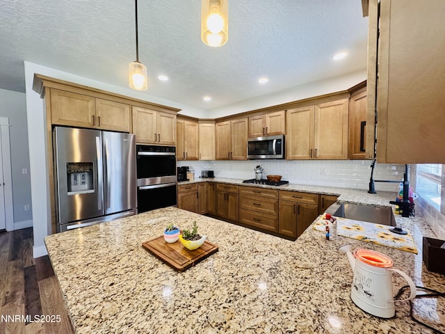 5290 Marla Dr, Winnemucca, NV 89445 - kitchen with stainless steel appliances, light stone countertops, decorative backsplash, a peninsula, and dark wood-style floors
