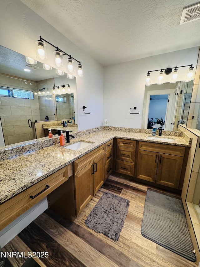 5290 Marla Dr, Winnemucca, NV 89445 - full bath with wood finished floors, a stall shower, a textured ceiling, and double vanity
