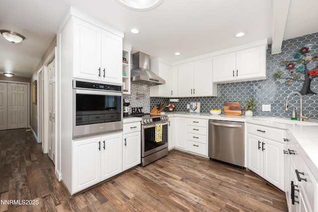4130 Snowshoe Ln, Reno, NV 89502 - kitchen with stainless steel appliances, wall chimney range hood, white cabinets, decorative backsplash, and dark wood finished floors