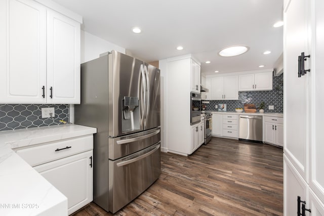 4130 Snowshoe Ln, Reno, NV 89502 - kitchen with stainless steel appliances, white cabinets, decorative backsplash, dark wood-type flooring, and recessed lighting