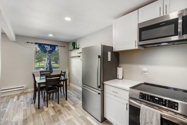 940 Jamaica Ave Unit 3, Reno, NV 89502 - kitchen with appliances with stainless steel finishes, a baseboard radiator, light wood-style floors, white cabinetry, and recessed lighting