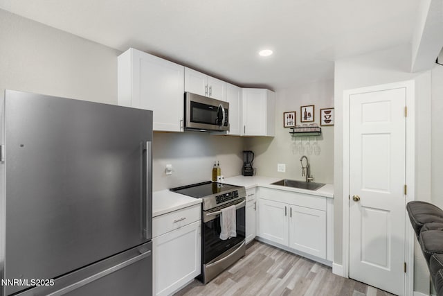 940 Jamaica Ave Unit 3, Reno, NV 89502 - kitchen with appliances with stainless steel finishes, light wood-style flooring, white cabinetry, light countertops, and recessed lighting