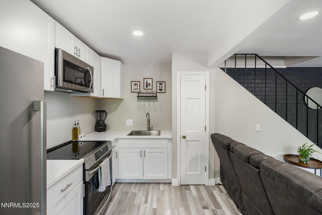 940 Jamaica Ave Unit 3, Reno, NV 89502 - kitchen featuring stainless steel appliances, light wood-style flooring, light countertops, white cabinets, and recessed lighting
