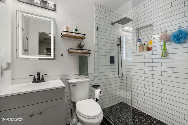 940 Jamaica Ave Unit 3, Reno, NV 89502 - bathroom featuring vanity, tiled shower, and tile walls