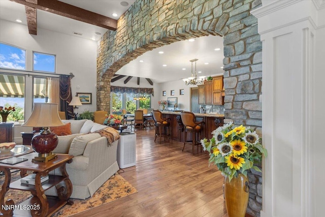 1555 Boulder Field Way, Reno, NV 89511 - living room featuring beamed ceiling, a chandelier, light wood-style flooring, arched walkways, and recessed lighting