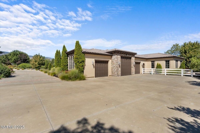1555 Boulder Field Way, Reno, NV 89511 - view of front of home with an attached garage, concrete driveway, stone siding, stucco siding, and a tiled roof