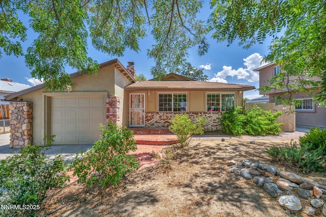 1320 Yori Ave, Reno, NV 89502 - view of front of home with a garage, stucco siding, a chimney, concrete driveway, and brick siding