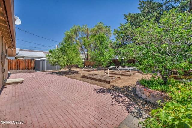 1320 Yori Ave, Reno, NV 89502 - fenced backyard with a vegetable garden, a shed, and a patio