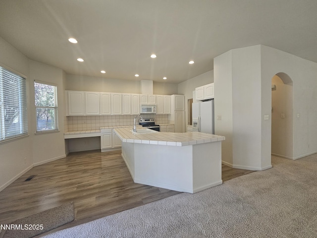 2735 Avenida De Landa, Reno, NV 89523 - kitchen featuring white appliances, tile counters, arched walkways, recessed lighting, and white cabinets