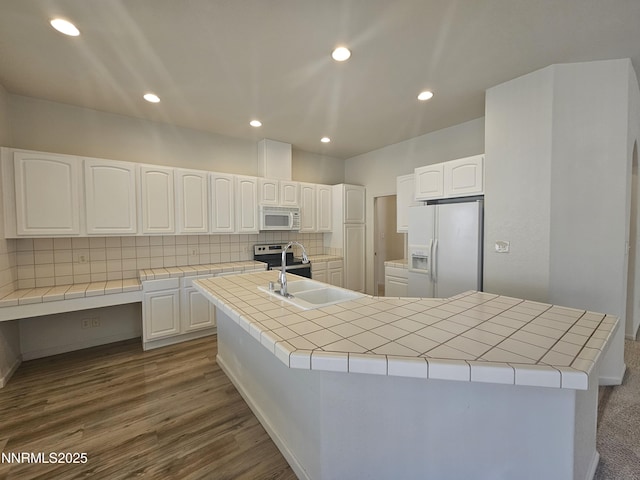 2735 Avenida De Landa, Reno, NV 89523 - kitchen featuring white appliances, tile counters, backsplash, white cabinetry, and a center island with sink