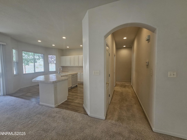 2735 Avenida De Landa, Reno, NV 89523 - kitchen with tile countertops, white dishwasher, arched walkways, light carpet, and white cabinetry
