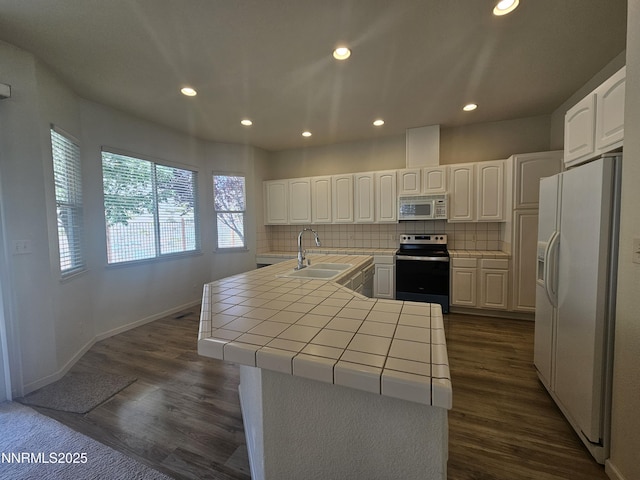 2735 Avenida De Landa, Reno, NV 89523 - kitchen with white appliances, tile countertops, decorative backsplash, recessed lighting, and white cabinetry