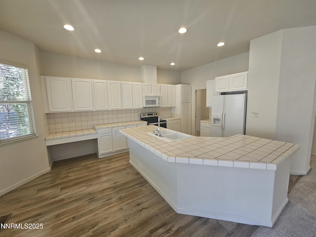 2735 Avenida De Landa, Reno, NV 89523 - kitchen with white appliances, tile countertops, backsplash, white cabinets, and dark wood finished floors