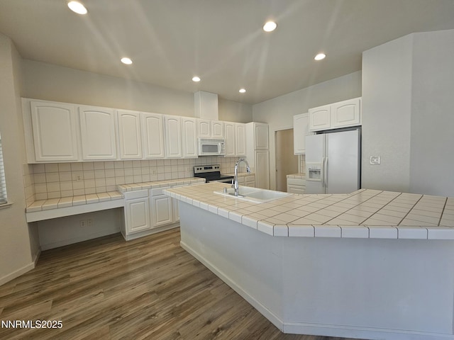 2735 Avenida De Landa, Reno, NV 89523 - kitchen featuring white appliances, tasteful backsplash, tile counters, dark wood finished floors, and white cabinets