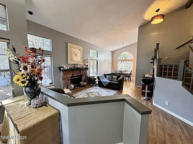 6673 Enchanted Valley Dr, Reno, NV 89523 - living area featuring wood finished floors, lofted ceiling, and a stone fireplace