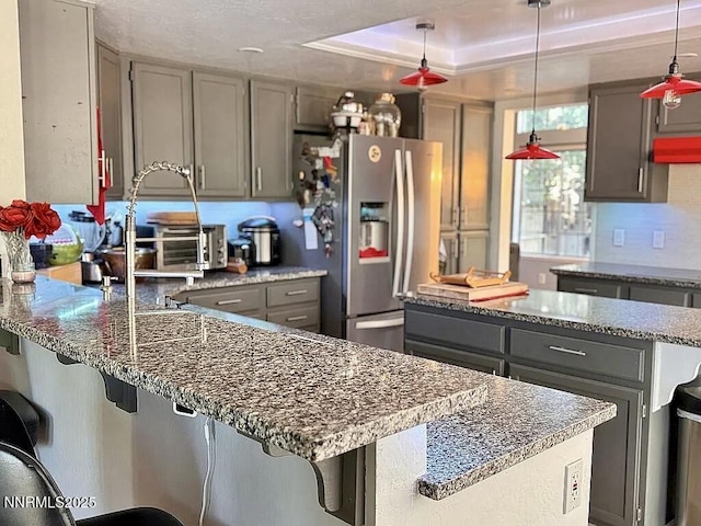 6673 Enchanted Valley Dr, Reno, NV 89523 - kitchen with gray cabinets, a peninsula, stainless steel fridge with ice dispenser, and dark stone countertops