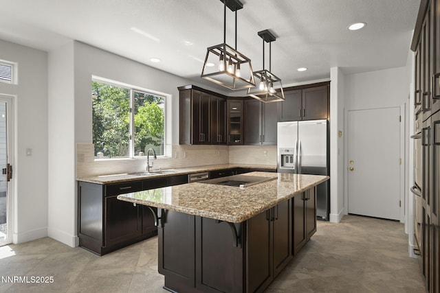 4033 Clover Creek Ct, Reno, NV 89519 - kitchen featuring stainless steel fridge with ice dispenser, dark brown cabinets, tasteful backsplash, light stone counters, and recessed lighting