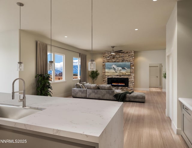 2769 Squires St, Minden, NV 89423 - kitchen featuring light wood finished floors, a fireplace, light stone counters, recessed lighting, and pendant lighting