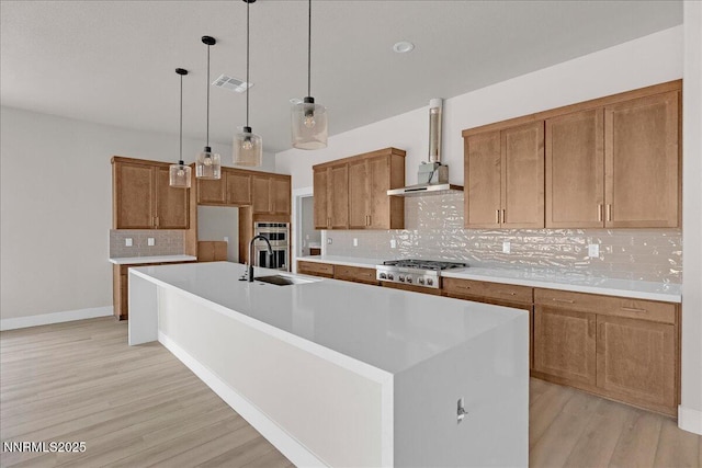 2800 Pamela Pl, Minden, NV 89423 - kitchen featuring tasteful backsplash, brown cabinetry, stainless steel appliances, light wood finished floors, and a spacious island