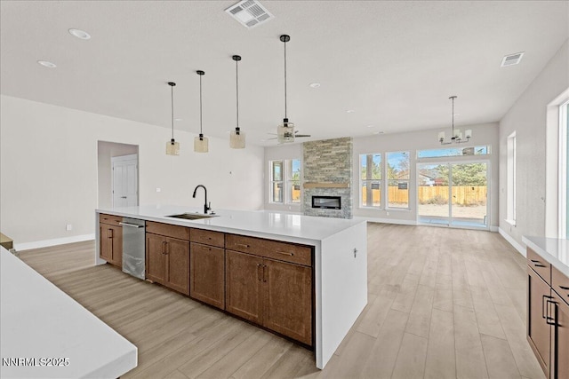 2800 Pamela Pl, Minden, NV 89423 - kitchen with dishwasher, light wood finished floors, light countertops, a fireplace, and a ceiling fan