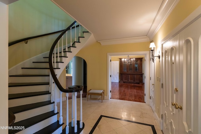 976 Caddie Ct, Incline Village, NV 89451 - foyer with inlaid floor details, stairway, ornamental molding, a chandelier, and light tile patterned floors