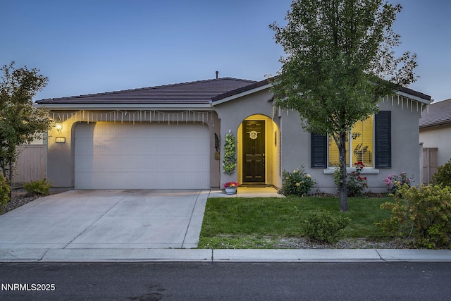 10125 Mesa Cortona Dr, Reno, NV 89521 - ranch-style home with an attached garage, driveway, a front yard, stucco siding, and a tiled roof