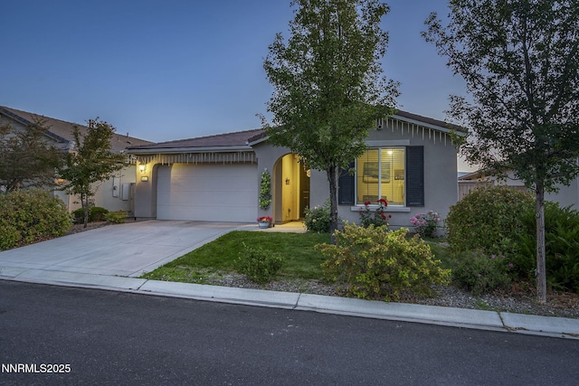 10125 Mesa Cortona Dr, Reno, NV 89521 - view of front of home with stucco siding, an attached garage, driveway, and a front lawn