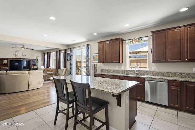 10125 Mesa Cortona Dr, Reno, NV 89521 - kitchen featuring stainless steel dishwasher, a breakfast bar, healthy amount of natural light, light tile patterned floors, and recessed lighting