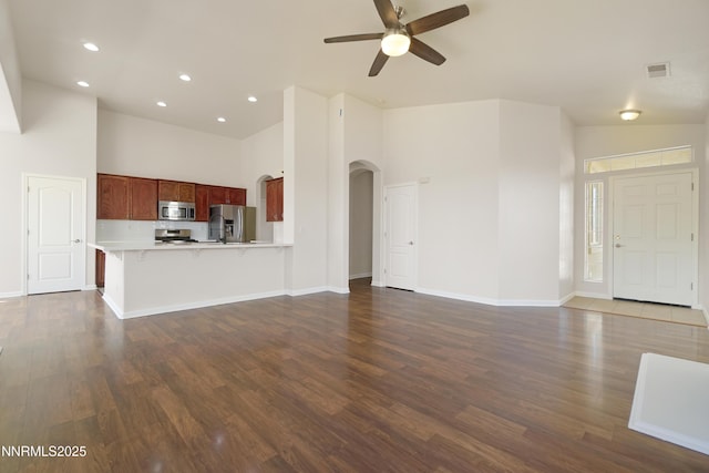 1723 Blue Oak Ct, Fernley, NV 89408 - unfurnished living room with arched walkways, a towering ceiling, a ceiling fan, dark wood finished floors, and recessed lighting
