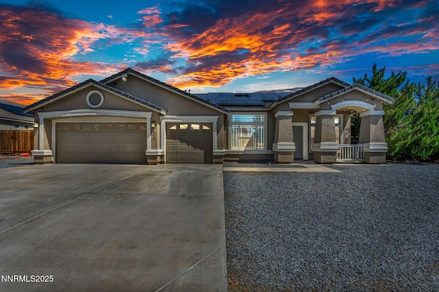 1048 Brierwood Ln, Fernley, NV 89408 - ranch-style house featuring an attached garage, driveway, stucco siding, roof mounted solar panels, and a tile roof