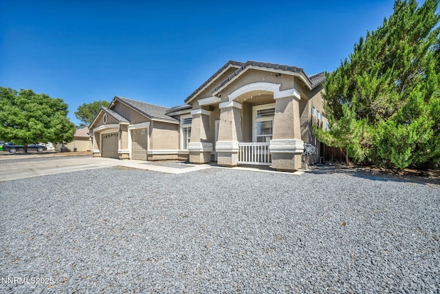 1048 Brierwood Ln, Fernley, NV 89408 - view of front of house featuring driveway, stucco siding, an attached garage, and covered porch