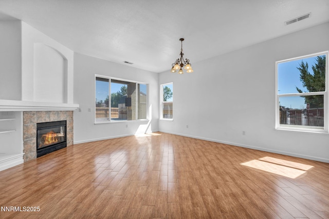 1048 Brierwood Ln, Fernley, NV 89408 - unfurnished living room with a chandelier, wood finished floors, and a tile fireplace