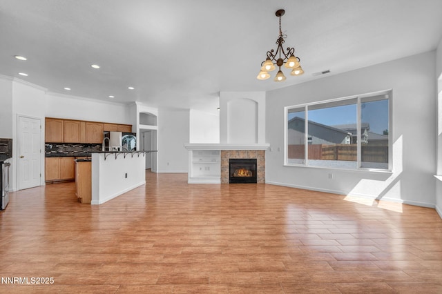 1048 Brierwood Ln, Fernley, NV 89408 - unfurnished living room featuring a chandelier, a fireplace, light wood finished floors, and recessed lighting