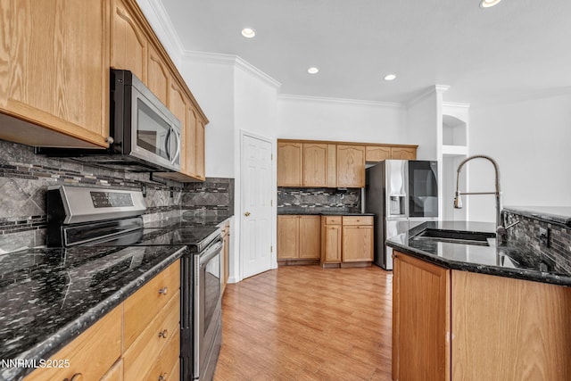 1048 Brierwood Ln, Fernley, NV 89408 - kitchen with appliances with stainless steel finishes, ornamental molding, backsplash, light wood-style flooring, and dark stone countertops