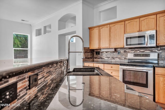 1048 Brierwood Ln, Fernley, NV 89408 - kitchen featuring stainless steel appliances, backsplash, ornamental molding, dark stone counters, and light brown cabinets