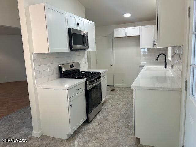 3220 Rice Rd, Fallon, NV 89406 - kitchen featuring appliances with stainless steel finishes, tasteful backsplash, white cabinetry, and light countertops