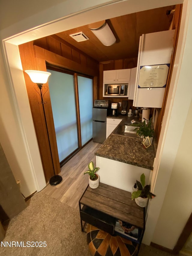 908 Harold Dr Unit 23, Incline Village, NV 89451 - kitchen with stainless steel appliances, white cabinetry, dark countertops, and light wood finished floors