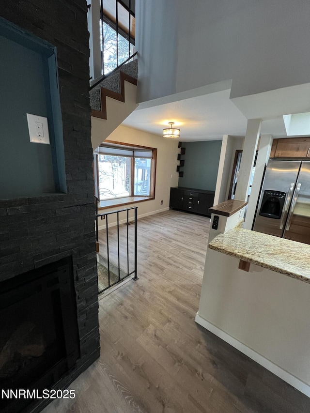 908 Harold Dr Unit 23, Incline Village, NV 89451 - living room featuring light wood-style floors, a fireplace, a high ceiling, and stairs