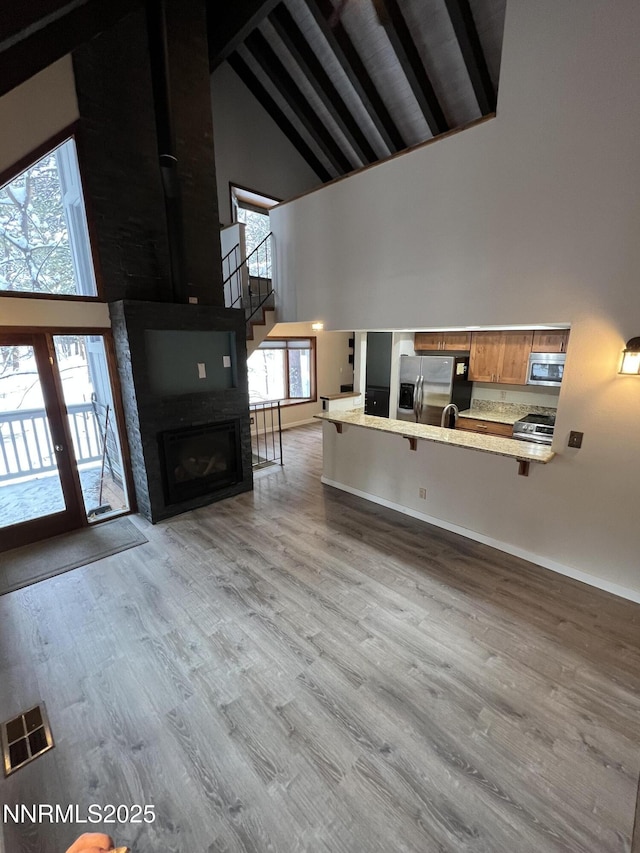 908 Harold Dr Unit 23, Incline Village, NV 89451 - unfurnished living room with high vaulted ceiling, beamed ceiling, wood finished floors, plenty of natural light, and stairs